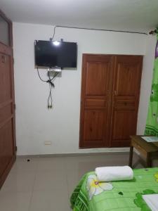 Habitación con TV de pantalla plana en la pared en Hostel Quintonido en Jarabacoa