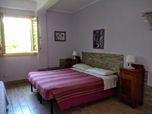 un dormitorio con una cama y una ventana en Casa Papaveri Rossi, en Finale Ligure