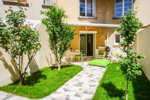 un jardin avec des arbres et une terrasse dans l'établissement Studio les Hortensias, à Avignon