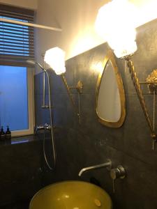 a bathroom with a yellow sink and a mirror at Bohemian apartment in the heart of old Ventspils city in Ventspils