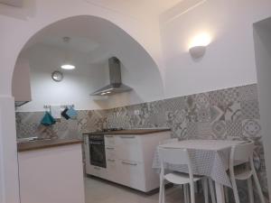 a kitchen with a table and chairs and a stove at La rosa dei venti in Gaeta