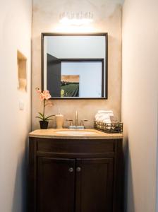a bathroom with a sink and a mirror at Cuatro Lunas Hotel Boutique in Valle de Guadalupe