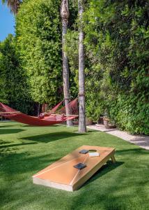 a wooden bench sitting on top of a lush green field at Santiago Resort - Palm Springs Premier Gay Men’s Resort in Palm Springs