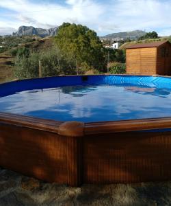 a large hot tub with a blue pool at Casa La Liebrecilla in Ríogordo