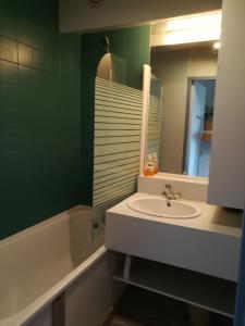 ein Badezimmer mit Waschbecken, Badewanne und Spiegel in der Unterkunft Le Plein Soleil 2 510 in Orcières