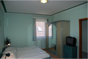 - une chambre avec un lit et une télévision dans l'établissement Apartmanház Cédrus 8 Zalakaros, à Zalakaros