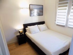 カネ・アン・ルシヨンにあるAppart Canetのベッドルーム1室(白いシーツ付きのベッド1台、窓付)