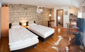a bedroom with two beds and a tv in it at Apartment Old Town Gverovic in Dubrovnik