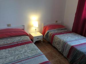 a bedroom with two beds and a lamp on a night stand at Rubama in Puerto del Carmen