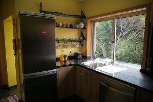 a kitchen with a refrigerator and a sink and a window at Braancamp 65 in Porto