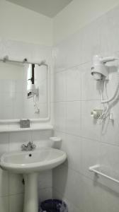 Baño blanco con lavabo y espejo en Appartamenti Calicante, en Bardolino