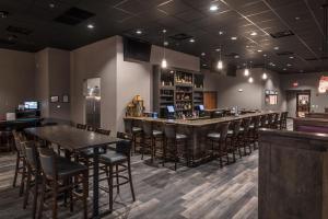 Astoria Extended Stay & Event Center في ديكنسون: بار في مطعم به طاولات وكراسي