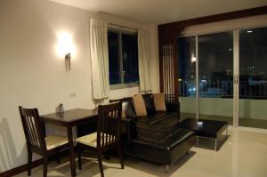 ein Wohnzimmer mit einem Sofa und einem Tisch in der Unterkunft Baan Manthana Hotel, Hua Hin in Hua Hin