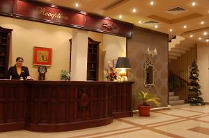 a woman standing at a counter in a lobby at Bucium Motel & SPA in Iaşi