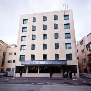 um grande edifício com pessoas do lado de fora em SeaNet Hotel By AFI Hotels em Tel Aviv