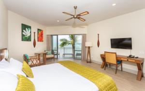 Dormitorio con cama, escritorio y TV en Moana Sands Lagoon Resort - Adults Only, en Rarotonga