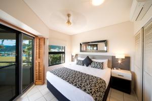 Portside Whitsunday Luxury Holiday Apartments tesisinde bir odada yatak veya yataklar