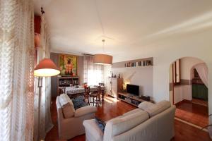 uma sala de estar com 2 sofás e uma sala de jantar em Tutti a casa di Pippo (100mq) em Peschiera del Garda