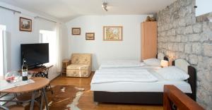 a bedroom with a bed and a tv and a table at Apartment Old Town Gverovic in Dubrovnik