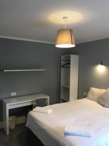 a bedroom with a bed and a desk and a lamp at Greenmount Bed and Breakfast in Belfast