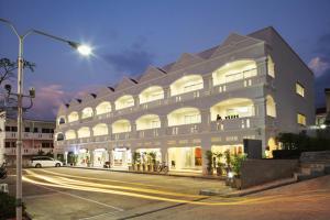 a large white building on a street at night at Samkong Place in Phuket Town