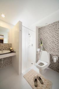 a bathroom with a toilet and a shower and a sink at Samkong Place in Phuket Town