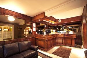 a living room with a leather couch and a bar at Hotel Albamar in Viña del Mar