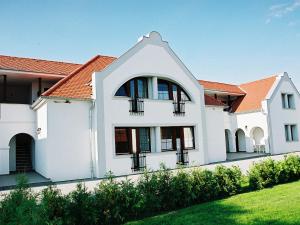 una casa blanca con techo naranja en Szanyi Vendégház en Hegykő