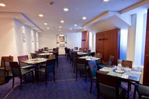 um restaurante com mesas e cadeiras em uma sala em SeaNet Hotel By AFI Hotels em Tel Aviv