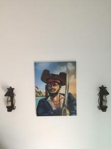 a painting of a man in a pirate hat on a wall at Pirata hostel Milfontes in Vila Nova de Milfontes
