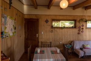 Zimmer mit einem Tisch, einem Stuhl und einem Fenster in der Unterkunft Cabañas La Misión in Niebla