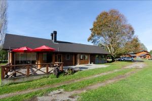 une maison avec un chien assis devant elle dans l'établissement Hotel Boutique Ecoterraverde, à Panguipulli