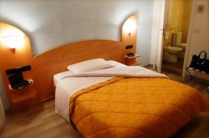 1 dormitorio con 1 cama grande y baño en Hotel Mirella e Ristorante Bar Don Bacco, en Orsago