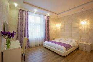 um quarto com uma cama, uma mesa e uma janela em Lviv Apartments em Lviv