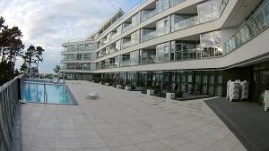 a large building with a swimming pool in front of it at DUNE Apartments in Mielno