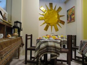 a dining room with a table with a sun on the wall at Maya Inn in Puno