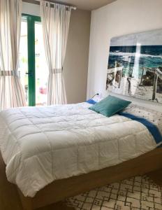 a bedroom with a bed with a picture on the wall at Playa Muchavista lovely ground floor apartment in El Campello +51 photos