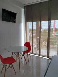 a dining room with a table and two red chairs at Hotel Gran Estacion Florencia in Florencia