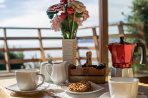 uma mesa com chávenas de café e um vaso com flores em Cabañas La Misión em Niebla