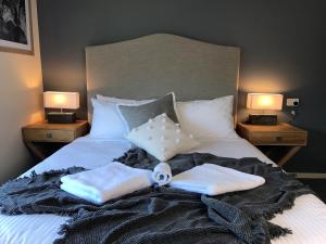a bed with two towels on it with two lamps at Ski Club of Victoria - Ivor Whittaker Lodge in Mount Buller