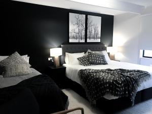 a bedroom with two beds with black walls at Ski Club of Victoria - Ivor Whittaker Lodge in Mount Buller