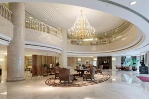 a lobby with a chandelier and a table and chairs at Hong Qiao State Guest House in Shanghai