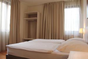 Schlafzimmer mit einem großen weißen Bett und einem Fenster in der Unterkunft Hotel Centro in Stuttgart