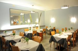 a dining room with tables and chairs and a mirror at Central-Classic Hotel in Stuttgart