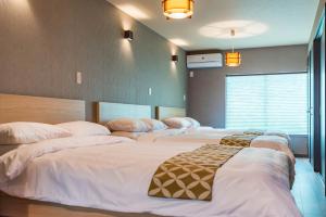 a group of four beds in a room at Bijou Suites Kakomi in Osaka
