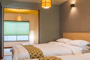 a bedroom with two beds and a window at Bijou Suites Kakomi in Osaka