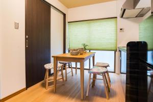 a dining room with a table and chairs and a window at Bijou Suites Kakomi in Osaka
