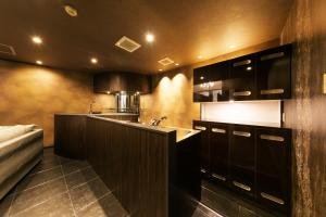 a kitchen with a counter and a sink in it at Hotel Eldia Modern Kobe(Adult Only) in Kobe