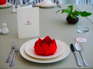a red flower on a plate on a table at The Kinn Bangkok in Bangkok