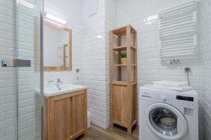 W łazience znajduje się pralka i umywalka. w obiekcie Chill Out Like A Local from Downtown Apt for 6 Free Parking w Gdańsku